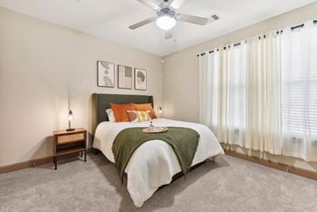 A bedroom with a bed and a ceiling fan